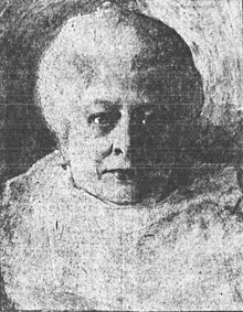 Black and white portrait of an older woman with her hair in an updo.