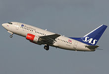 A medium-sized twin-engined jetliner with red engines and a blue tail