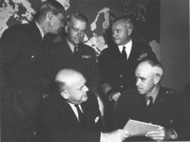 Secretary of Defense Louis Johnson (seated, left), confers with General Omar N. Bradley (seated, right), Chairman of the Joint Chiefs of Staff, at an informal press conference. Standing left to right are: General Hoyt S. Vandenberg, Chief of Staff, USAF; General J. Lawton Collins, Chief of Staff, USA; and Admiral Forrest P. Sherman, Chief of Naval Operations, USN.