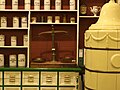 Apothekerwaage und klassizistischer Ofen