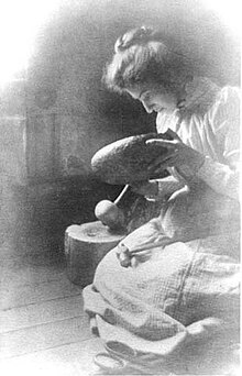 Seated woman making a metal bowl