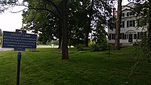 a picture of the marker with the large white house behind it