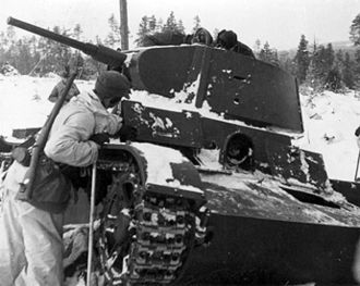 Swedish soldiers inspecting a destroyed Soviet tank