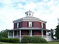 Perfectly octagonal brick house with veranda, pitched roof and lantern. Wilcox Octagon House, Camillus, New York (built 1856).
