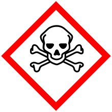 A hazard symbol depicting a human skull in front of two bones crossing between one another.