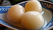 Trois tangyuan ou boules de pâte de riz gluant dans une cuillère.