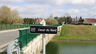 Entrée du village et le pont sur le Canal du Nord (France).