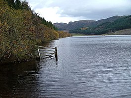 A lake surrounded by trees and hills