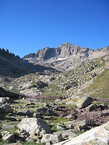 Photographie d'une montagne rocheuse vue d'en bas.