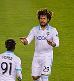 A man wearing a white shirt and shorts.