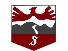 Vehicle insignia in the shape of a badge, depicting a red bird flying over grey hills.