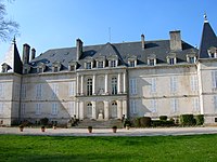 Large, two-story white building with gray slate roof