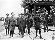 Heinrich Himmler, head of the SS, visiting the IG Farben plant, Auschwitz III, in German-occupied Poland, July 1942. His visit included watching a gassing, while he was inspecting the expansion of Auschwitz II, the extermination camp, and Auschwitz III, an IG Farben (BASF) plant.[194]