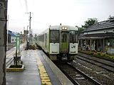 旧ホームに入線する飯山線列車と旧駅舎（2007年8月）