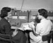 Two women discussing their work while entering data onto punched cards at Texas A&M in the 1950s