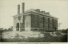 Black and white photo of a three-storey brick building
