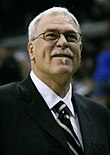 A man looking ahead. He is wearing a jacket and tie.