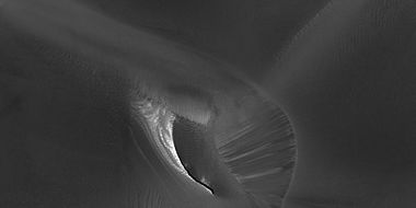 Close view of white spot among the dark dunes showing ripples and streaks