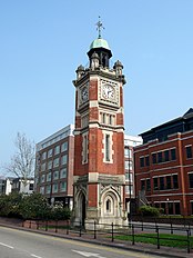 A brick tower with a clock face at its top