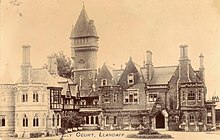Sepia postcard photograph of ivy-clad sandstone mansion