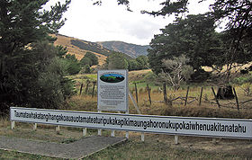 Vue du panneau au départ du sentier menant à la collinevisible au dernier plan.