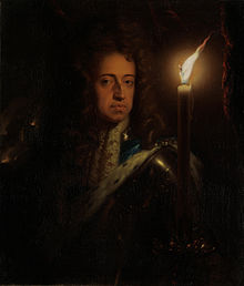 A dark portrait of William holding a candle