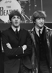 Paul McCartney and John Lennon standing together.