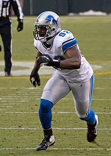 Cliff Avril in a full Detroit Lions uniform and helmet running.