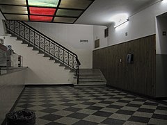 Interior del edificio, mostrando una barra de buffet, unos plafones con luces de color y una escalera que asciende