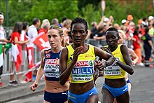 Au premier plan, Joan Melly courant avec le maillot jaune de la Roumanie. Derrière elle, Karoline Bjerkeli Grøvdal court avec le maillot bleu de la Norvège.