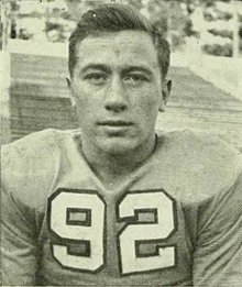 An American football player looking at the camera while wearing his jersey.