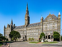 A large Gothic-style stone building dominated by a tall clocktower.