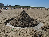 A sandcastle with a moat, at low tide