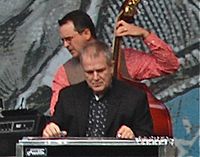 Musician Paul Franklin, seated while playing a pedal steel guitar.