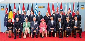 Seated left to right are: Governor-General of New Zealand Patsy Reddy, French president Emmanuel Macron, British prime minister Theresa May, Prince Charles, Queen Elizabeth II, US president Donald Trump, Greek president Prokopis Pavlopoulos, German chancellor Angela Merkel and Dutch prime minister Mark Rutte