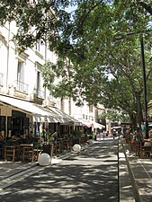 Juillet 2010, vue de l'allée bordant les cafés de la place.