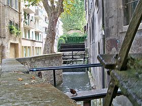 Gros plan sur une roue et canal bordant la rue des Teinturiers