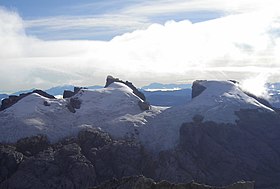 Vue du versant sud du Nga Pulu (calotte neigeuse à droite) et du Sumantri (pic rocheux au centre) depuis le sommet du Puncak Jaya (photo de Christian Stangl).