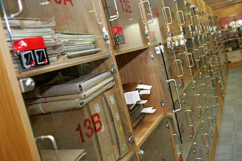 Various documents curated for readers at the National Archives, UK. Arranged in boxed shelving with glass doors.