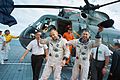 Photographie en couleur d'Aldrin et de Lovell sortant de l'hélicoptère de récupération sur le pont du porte-avions Wasp.