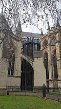 A black tower on the side of the brown stone abbey