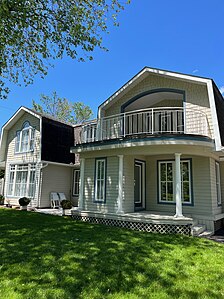 a) Arched, inset upper balcony,[2] b) Front verandah[83] (built, 1982)