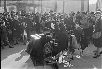 Musicians perform in the streets of Paris in the spring of 1945. The crowd includes several allied soldiers (Imperial War Museums, U.K.)