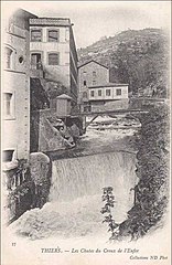 Vieille photographie de la cascade du Creux de l'enfer avec une annexe des forges Mondière en arrière-plan à droite.