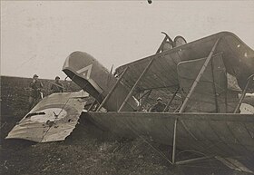 Photo noir et blanc de militaires posant devant une carcasse d'avion.