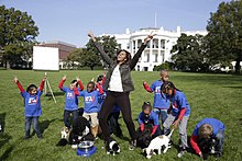 First Lady Michelle Obama and students on White House lawn with puppies
