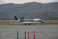 An aircraft located on a runway, with a mountain in the background.