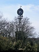 Photographie en couleurs d'une roue à pales au sommet d'un mât en treillage métallique