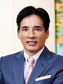 An image of Hori in a blue suit with tie.