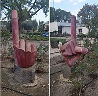 שני צדדיו של פסל כף יד עם אצבע המונפת אל על בהתרסה , בגן באשדות יעקב איחוד